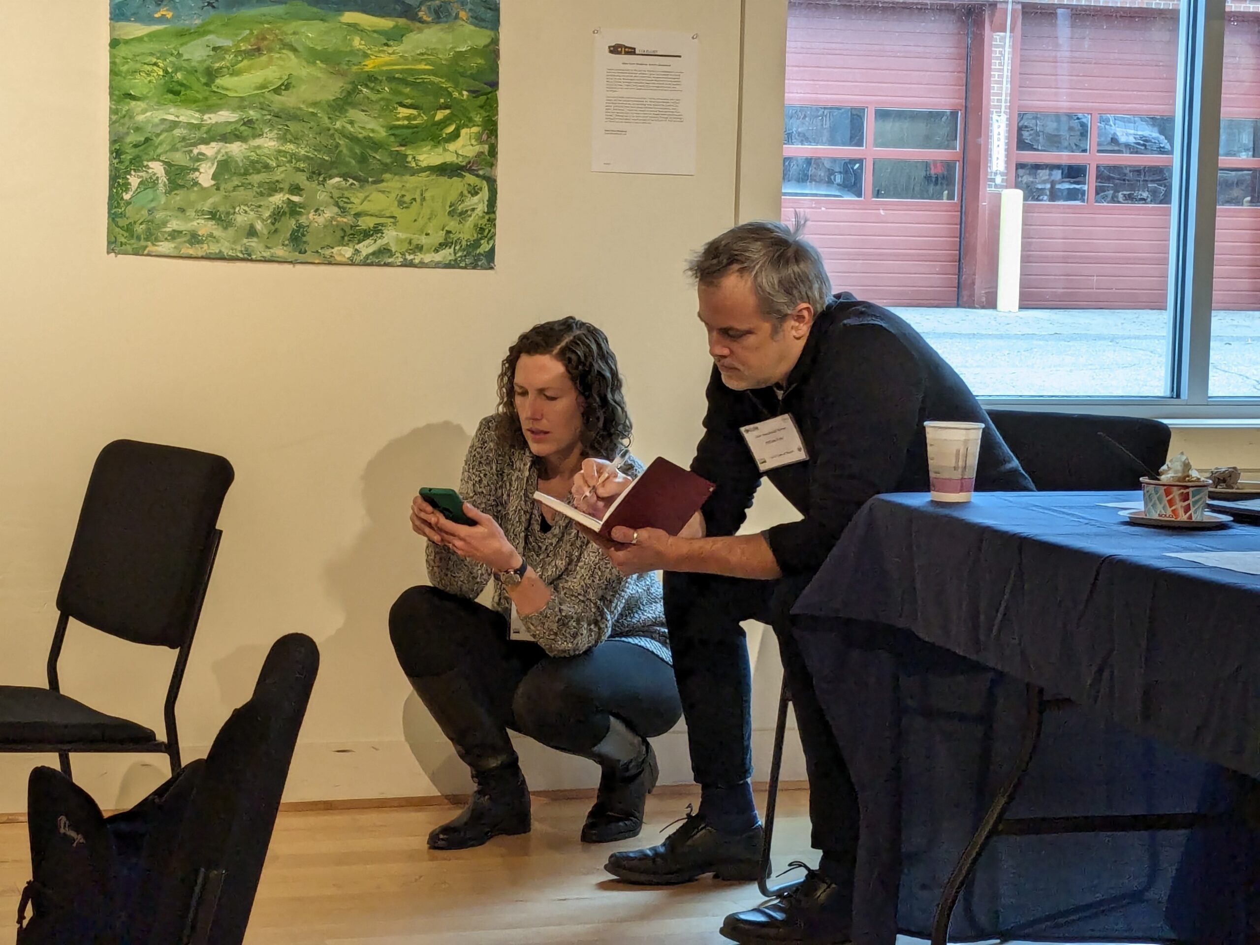 Two people check their calendars to plan a time to meet