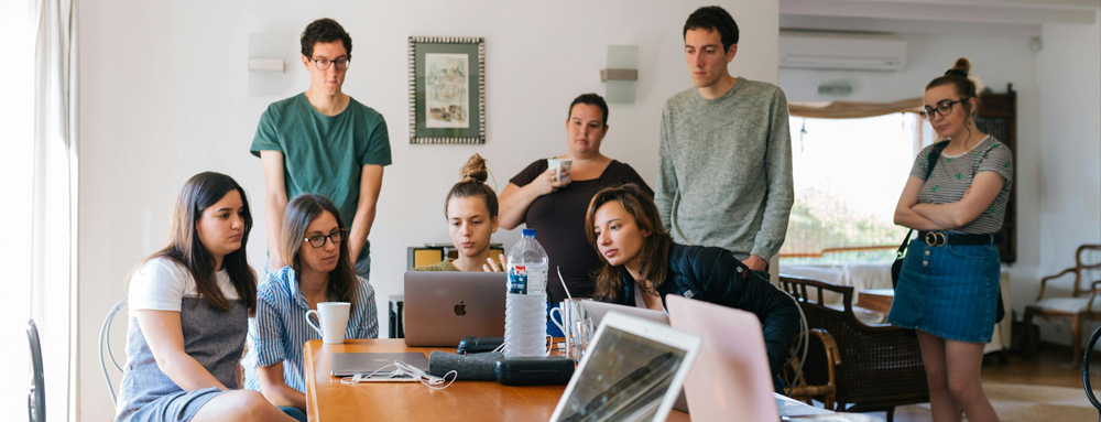 a group of young people gathered around a meeting table