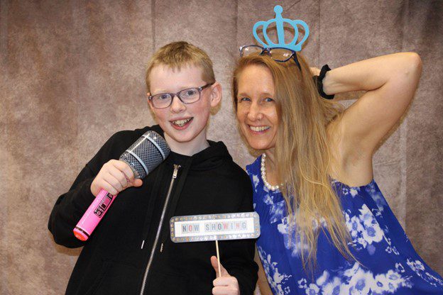 Teacher and student posing for photo at photo booth