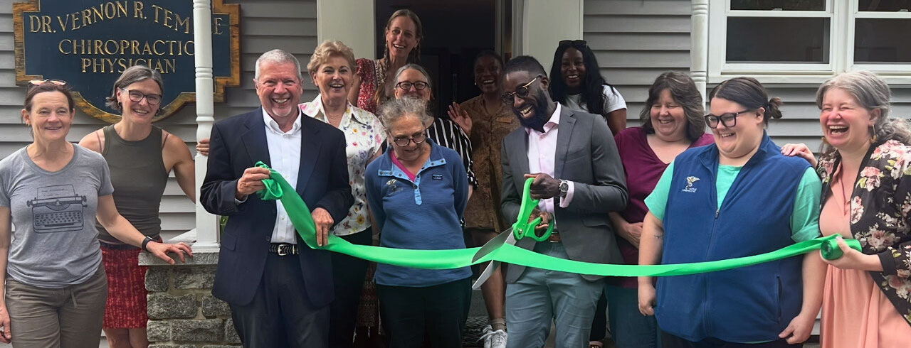 a group of happy people at a ribbon cutting